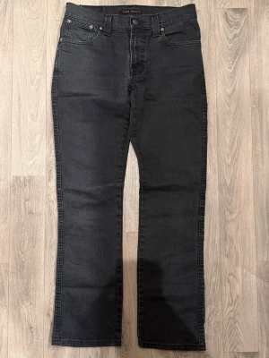 Nudie Jeans Slim Jim Mörkgrå W31 L32 - Mycket fint skick. Storlek W31/L32. Mått - Midja: 38,5cm, Ytterbenslängd: 99cm, Benöppning: 19,5cm. Modellen är 185cm & 63kg. Hör av dig vid funderingar!🤝