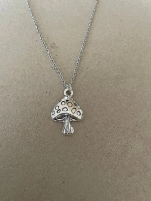 Halsband svamp  - Min dotter och ja pysslar/ gör smycken som hobby.   Kedja 50cm rostfritt stål  Berlock : zinklegering  Bud accepteras inte