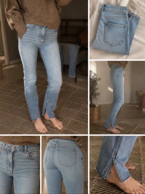 Ljusblå jeans med slits nertill - Snygga ljusblå jeans med raka ben och trendig slits framtill vid bensluten. Klassisk femficksmodell och hög midja. Perfekta för en avslappnad och cool stil. Jeansen har en enkel design utan slitningar och är tillverkade i denim.