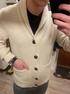 Vit stickad cardigan  - Otroligt snygg beige/vit stickad cardigan från Abercrombie & fitch. Passar perfekt till lite kyligare sommarkvällar. Modellen är 180cm, 75kg. Priset kan såklart diskuteras