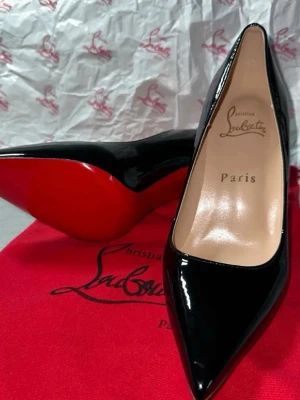 Christian Louboutin klackskor - Christian Louboutin klackskor i svart lack, storlek 37.Levereras med röd påse med Christian Louboutin-tryck enligt bild, lådan finns. Priset kan diskuteras.