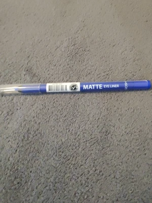 Blå matt eyeliner från Gosh - Säljer en matt eyeliner från Gosh i en snygg blå nyans. Pennan har klassisk form med genomskinligt lock och är enkel att applicera för en definierad look. Perfekt för dig som vill ha en färgstark och trendig eyeliner.
