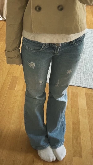 Blå bootcut jeans från ltb - Säljer ett par ljusblå bootcut jeans med hål. Jeansen har klassisk femficksmodell och låg midja. Perfekta för en avslappnad och trendig look. fråga gärna om ni har frågor eller vill ha fler bilder 🩷