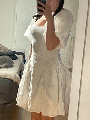 Vit kort klänning med puffärmar - Söt vit kort klänning med puffiga kortärmar och rundad urringning. Kjolen är lite utställd åt sidorna. Passar inför studenten eller andra tillfällen. Jag är 156 men tror att klänningen hade suttit bättre på någon som är aningen längre. Aldrig använd med prislapp kvar, har endast provat den. 