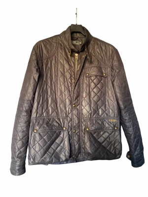 Polo Ralph lauren jacka  - Snygg svart quiltad jacka från polo Ralph lauren med hög krage, tryckknappar och dragkedja. Jackan har flera fickor framtill med lock och guldiga detaljer. Klassisk design i lätt glansigt material, perfekt jacka nu till våren 🍃☀️