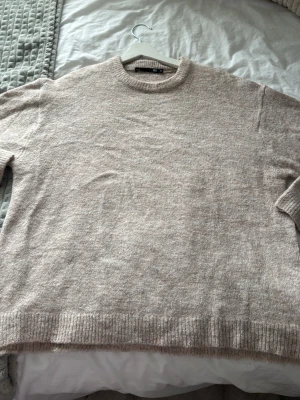 Beige stickad tröja från 157 - Mysig beige stickad tröja från 157 med rund halsringning och ribbade muddar vid ärmslut och nederkant. Perfekt för lager på lager och enkel att matcha med olika outfits. Tröjan har en mjuk och skön känsla. Tröjan är i XS men är väldigt stor i storleken därför säljer jag den💞