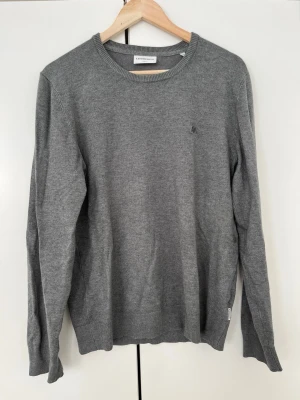 Grön-grå tröja från Lindbergh - Snygg tröja från Lindbergh i slim fit-modell. Tröjan har rund halsringning, långa ärmar och diskret logga på bröstet. Perfekt basplagg i mjukt material som passar till allt. Den ser grå ut på bilderna men den har en touch av grön nyans i sig. Storleken är S och om du har M går det bra ändå! Hör alltid av dig om du vill diskutera priset! 