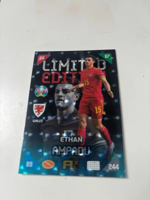 Limited Edition fotbollskort UEFA 2020 - Säljer ett Limited Edition samlarkort från Panini Adrenalyn XL UEFA Euro 2020. Kortet föreställer en walesisk mittfältare i röd matchdräkt med nummer 15. Kortet har holografisk yta och flera officiella logotyper. Perfekt för samlare av fotbollskort.