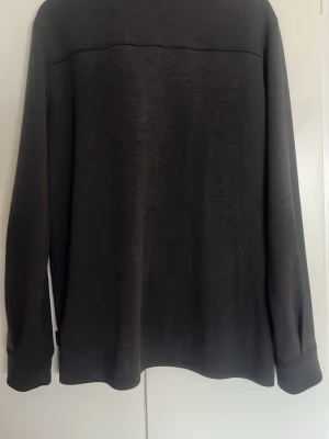 Mörk Grå overshirt med knappstängning - Stilren svart overshirt med klassisk krage och knappstängning framtill. Overshirten har två bröstfickor  och långa ärmar. Matrialet är sjukt skönt och passar perfekt för våren som kommer men även till kalla sommar kvällar.