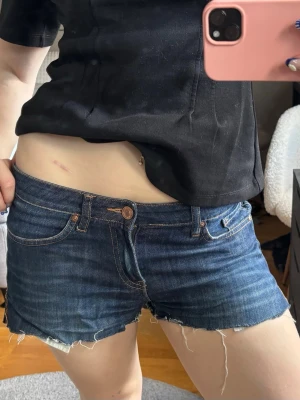 Jeansshorts - Snygga mörkblå jeansshorts med klassisk femficksdesign. Shortsen har låg midja och är perfekta för varma dagar. Stängs med knapp och dragkedja framtill. Priset är diskuterbart vid snabb affär🥰 