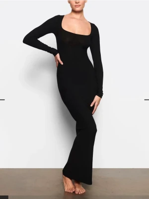 Svart långärmad långklänning - Säljer en svart långklänning med lång ärm och fyrkantig ringning. Klänningen har en tight passform och är tillverkad i ett stretchigt material som sitter snyggt på kroppen. Perfekt för dig som gillar minimalistisk och stilren design.