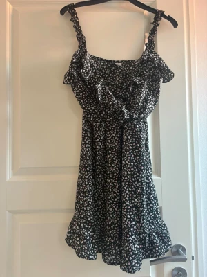 Svart  volangklänning - Svart klänning med blommor från H&M i storlek S💕
