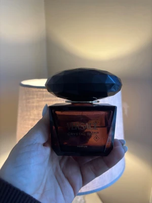 Versace Crystal Noir Parfym - Versace Crystal Noir är en lyxig parfym i en mörklila. Doften är känd för sin mystiska och sensuella karaktär, perfekt för dig som gillar exklusiva och djupa dofter.70 procent kvar av flaskan 