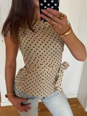 Prickig topp med knytning - Så fin prickig topp med knytning i midjan. Jag är 168 och det är mina bilder, köp via köp nu direkt eller Swish, kvar tills markerad som såld 💖 obs, storlek på lappen är 44 men den passar M