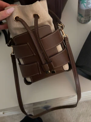 Hm bucket väska - Jätte populär och i bra skick. Har en liten defekt på undersidan men inget märkvärdigt🥰 långt band tillkommer!!