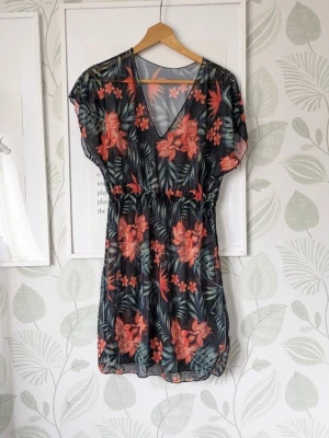 Strandklänning Tunika Storlek S-M - - Jätteskön tunn och snygg  strandklänning att ha över badkläder på stranden. - Luftig och tunn . - I polyester, elastan. - Storlek S men passar även mindre M - Oanvänd. - Hittar inget att anmärka på men jag kan ha missat någon miniskavank men jag har försökt att granska så gott det går.  - Köpt förra sommaren och tror det var från Amazon, wish eller liknande men är ej 100.