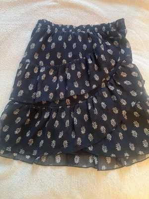 Kjol - Säljer en svart kjol med möbster på har inte kommit till användning mycket så därför säljer jag ( priset kan diskuteras) // nytt pris 300 kr 🩷