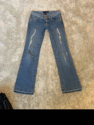 Blå bootcut jeans med slitningar - Säljer dessa väldigt coola jeansen med slitningar på låren! De är i väldigt bra skick och är lågmidjade och utsvängda, skriv vid frågor😊 Midjemått: 37cm Innerbenslängd: 76cm Grenhöjd: 19cm  🌺Kolla gärna in min profil då jag säljer många fler saker! 🌺Följ för att se när jag lägger upp nya saker! 🌺Jag reserverar inte