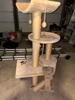 Kattställning - Säljer ett beige klösträd för katter med flera nivåer, klöspelare i sisal, två hängande bollar, en liten koja och en lutande klösbräda. Perfekt för lek och vila. Ena plattan har tassavtrycksmotiv.