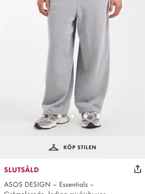 Gråmelerade mjukisbyxor ASOS DESIGN - Gråmelerade mjukisbyxor från ASOS DESIGN med avslappnad passform och dragsko i midjan. Byxorna har breda ben och resår vid bensluten. Perfekta för en chill och bekväm stil. Tillverkade i mjukt sweatshirtmaterial.