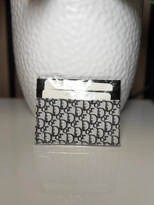  korthållare i monogramtyg - . Liten och smidig att ha i fickan eller väskan.