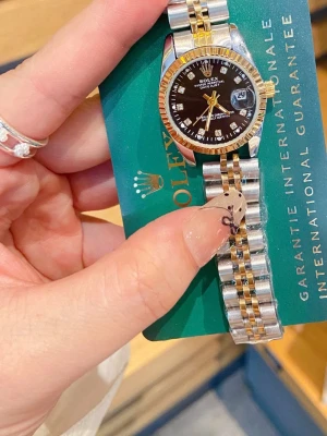 Justerbar Klassisk tvåtonad klocka med svart urtavla  - Snygg klocka i silver och guld med svart urtavla och guldfärgade detaljer. Länken är i metall med tvåtonad design och urtavlan har tydliga indexmarkeringar. Perfekt accessoar för dig som gillar stilrena och tidlösa detaljer. 