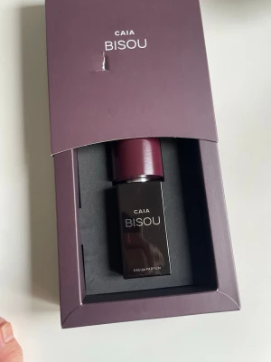 CAIA Bisou Eau de Parfum 50ml - Ny Snygg parfym från CAIA i modellen Bisou. Flaskan är mörklila och har en stilren, fyrkantig form med matchande lila lock. Kommer i en elegant ask som gör den perfekt att ge bort eller ha framme på hyllan. Doften är Eau de Parfum.