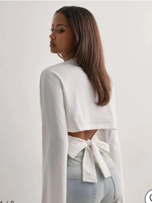 Vit långärmad topp med knyt i ryggen - Tröja ifrån Nelly, andvända 1 gång
