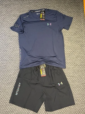 Under armour set - Snyggt marinblå träningsset från Under Armour med t-shirt och shorts. Perfekt som träningskläder men också till sommaren. Storleken är L men den passar perfekt som S-M. Ifall ni har några funderingar så är det bara att fråga