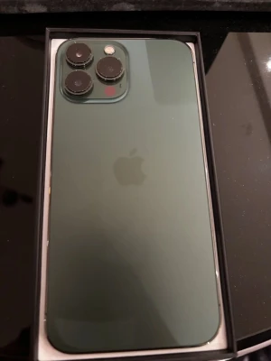 Apple iPhone 13 Pro Max 128 GB Alpine grön - iPhone 13 Pro Max Alpine Green i bra skick      Mycket tillbehör ingår:     1x original kartong  1x magnetisk laddare med kabel  1x laddkabel  3x skärmskydd i glas  3x mobilskal i olika stil  1x SD-kortläsare  1x Hörlurar     Perfekt för någon som vill få många tillbehör direkt utan att behöva köpa extra.