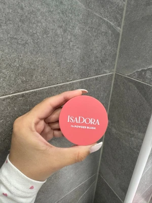 IsaDora Powder Blush Coral Pink - IsaDora The Powder Blush i färgen Coral Pink är ett pressat puderrouge i en rund, kompakt dosa. Färgen är en fräsch korallrosa nyans som ger kinderna ett naturligt glow. Vegansk och parfymfri formula, tillverkad i Sverige. Använd 2 gånger!!! 