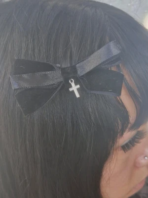 Rosett håraccessoarer med kors  - Rosett håraccessoarer med kors hängandes. Svart gjord av satin och velvet band.