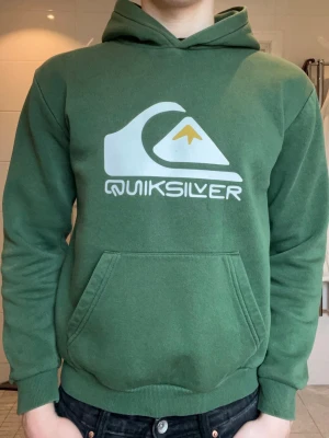 Quiksilver hoodie  - Snygg grön hoodie från Quiksilver i storlek S , med stor vit och gul logga på bröstet. Knappt använd och bra skick. 