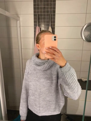 Grå stickad polotröja - En riktigt mysig grå stickad polotröja med bred krage och ribbstickat mönster. Tröjan har långa ärmar och en något boxig passform som är perfekt för lager-på-lager. Materialet är mjukt och varmt, idealiskt för kyliga dagar. Storlek 170 men passar bra på nån med XS/S också!! 