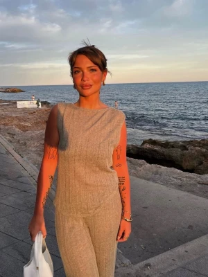 Grönt  ribbat set med öppen rygg  - Säljer ett stilrent grönt set med ärmlös topp som har öppen rygg. Man kan även byta håll på tröjan. Sen är det matchande  byxor till. Storlek S från pull and bear. Använt endast 1 gång. 200:- för hela setet.