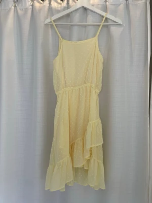 Ljusgul volangklänning  - Söt ljusgul klänning från KappAhl med tunna axelband och volangdetaljer. Klänningen har ett prickigt mönster🌸🌼