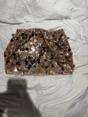 Kort paljettkjol i guld - En guldig paljettkjol!! Så fin, lågmidjad. Inga inbyggda shorts! Den sitter super 