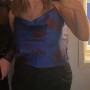 Blåmönstrad festtopp från Monki - Säljer en blåmönstrad festtopp i satin från Monki.  Storlek S. Använd fåtal gånger!