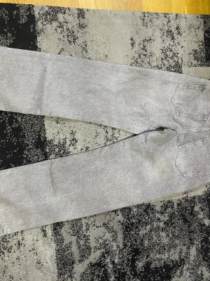 Grå loose fit jeans från SAM - Säljer ett par ljusgrå jeans från SAM i loose fit-modell med regular waist. Jeansen har raka ben och två bakfickor. Perfekta för dig som gillar en avslappnad och trendig stil. Materialet är klassisk denim i bomull.