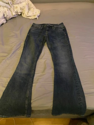 Mörkblå bootcut jeans Crocker  - Säljer ett par mörkblå bootcut jeans med klassisk femficksdesign och utsvängda ben. Jeansen har en snygg tvättad look och är perfekta för dig som gillar retrostil. Passar till många olika outfits och är riktigt bekväma.