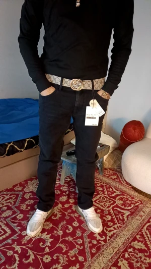Svarta jeans från Blend straight fit helt nya  - Svarta jeans från Blend med klassisk femficksdesign och rak passform. Jeansen har normal midja och är tillverkade i mjukt bomullsmaterial med lite stretch för extra komfort. Snygg stil som funkar till sneakers och t-shirt. Helt nya byxor storlek 32 32 passar smal medium 160-180 köptes för 900 som sagt endast testad hemma och dom är varken för tajta eller breda sitter perfekt kan säljas med bältet paket pris 700