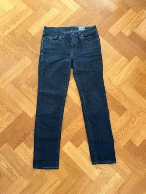 Mörkblå raka jeans från G-star raw - Snygga mörkblå jeans från G-star raw med rak passform och klassisk femficksdesign. Jeansen har diskreta sömmar och en patch med logga bak i midjan. Tillverkade i mjuk denim med lite stretch för extra komfort.