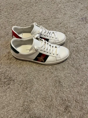 Gucci Ace Bee sneakers - Säljer nu mina klassiska Gucci Ace Bee i storlek 41 då de inte kommer till användning längre. En tidlös sneaker som passar till det mesta! • Skick: Skulle säga 8/10. De är välvårdade men lite använda. • Tillbehör: Inga tillbehör (box eller dustbag) finns kvar då dessa dessvärre slängdes i samband med en flytt. Pris: 1999 kr (Nypris: ca 7 000 kr) Först till kvarn gäller!
