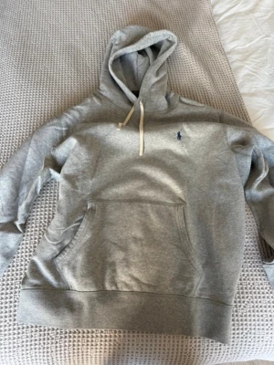 Grå hoodie från Polo Ralph Lauren - Snygg grå hoodie från Polo Ralph Lauren. Köpte för ca 1 år sedan och inte använt den så mycket, vilket gör att den är i mycket bra skick!