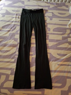 Svarta utsvängda byxor - Svarta utsvängda byxor från lager 157 i strl 160cm. Välanvända och har många hål (se bilder) och säljer därför dem till billigt pris. Hålen synns knappt när man har på sig dem och är nog lätta att sy ihop. Köp gärna en bundle för att spara på frakten!