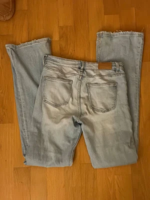 Ljusblå lågmidjade jeans - Säljer ett par ljusblå utsvängda jeans! Perfekt nu när sommaren snart är här.💕Jeansen är i bra skick men har lite slitningar längst ner på benen vilket syns på bilden. De är från Gina i storlek 158 men passar ungefär som storlek xs!