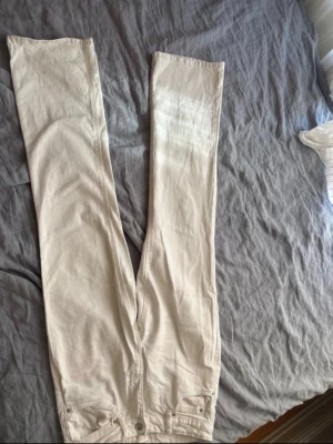 Vita raka jeans från Gina tricot  - Säljer ett par vita jeans från Gina i rak modell. Jeansen har klassisk femficksdesign, bälteshällor och knappgylf. Perfekta till alla typer av outfits! Jeansen är i storlek 36 då midjemåttet är ca, 35cm. Samt är de aldrig använda.