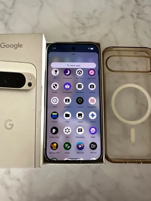 Google Pixel Android-telefon svart - Säljer en Google Pixel Android-telefon i svart med stilren design och rundade hörn. Telefonen har en stor skärm med tunna kanter och en kamera med bred lins på baksidan. Medföljer originalkartong och ett genomskinligt skal med MagSafe-ring.
