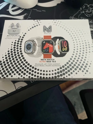 Meta Watch Ultra Max 10.0 smartklocka - Meta Watch Ultra Max 10.0 smartklocka med fyrkantig display, svart silikonarmband och silverfärgad boett. Klockan har Bluetooth-samtal, röstassistent, sportläge och hälsoövervakning. Laddare och tillbehör medföljer i paketet. Helt ny säljer för 900 pris kan diskuteras vid snabb affär