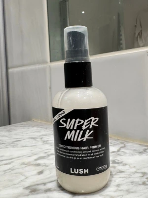 LUSH Super Milk hårprimer 100g - Super Milk Conditioning Hair Primer från LUSH är en leave-in spray med mandel-, kokos- och havremjölk. Kommer i en vit plastflaska med svart etikett och spraymunstycke. Perfekt för att återfukta och reda ut håret utan att tynga ner. Se sista bilden hur mycket som finns kvar. 
